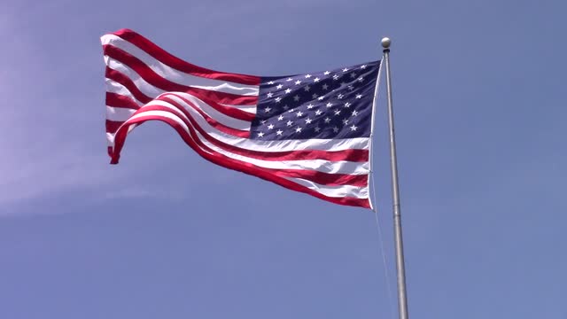 American flag flag blowing in the wind flag against a blue sky