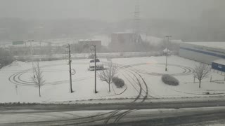 Driver Does Donuts in Parking Lot During Snow Storm