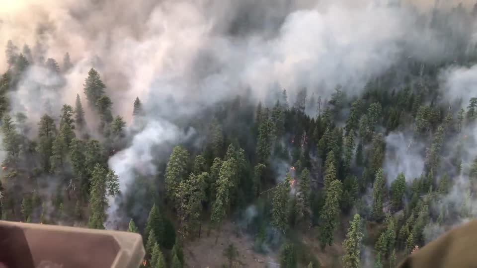 A helicopter flies over active flame during the Canyon 66 Prescribed fire