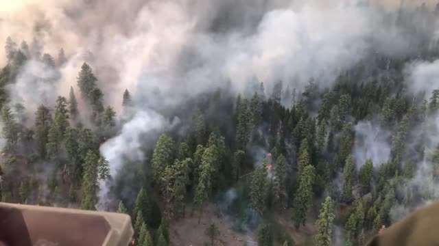 A helicopter flies over active flame during the Canyon 66 Prescribed fire