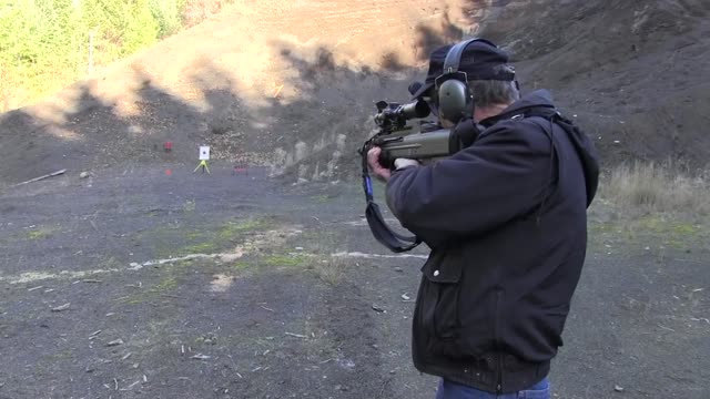 A man firing a gun at a target in a gravel pit on the Mt. Hood National Forest