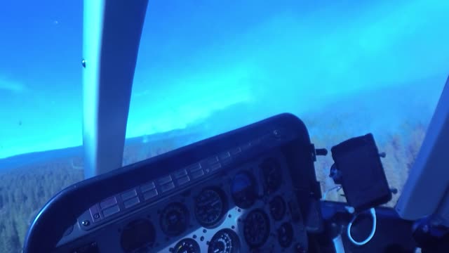 Crew Member Surveys Smokey Forest from a Helicopter